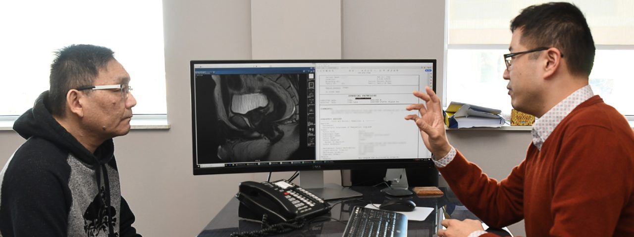 doctor and patient sit infront of a monitor and look at a bowel scan