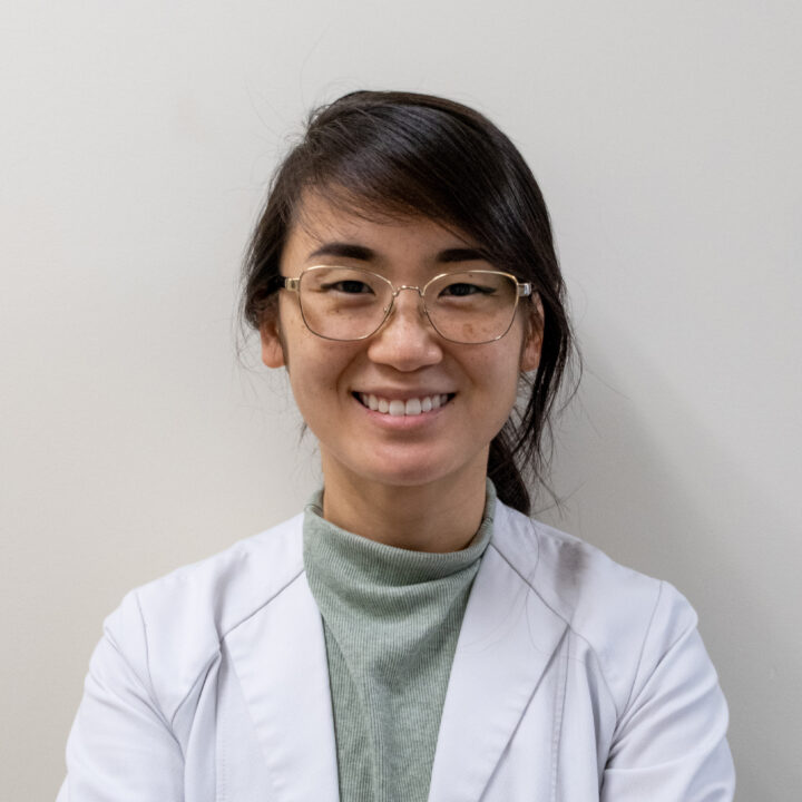 Headshot of Dr. Li, who is wearing a grey turtleneck underneath a white hospital coat and glasses.