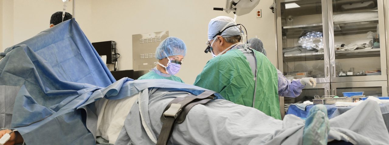 several doctors prepare for surgery on a patient