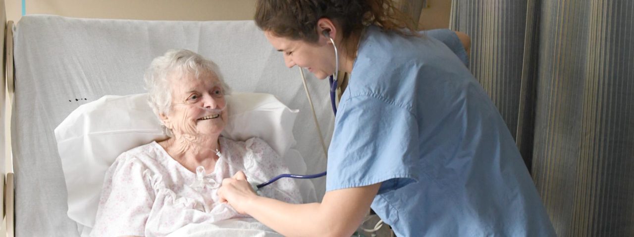 a nurse checks an elderly patient's heart