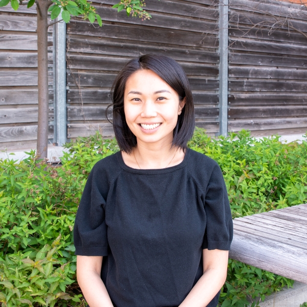 Jessica Tsang, from the waist up, wearing a black shirt and short black hair, smiling