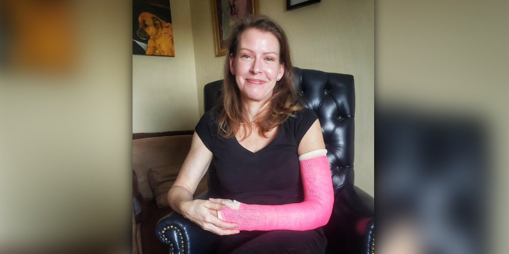 Kerry Young, wearing a black shirt and pink arm cast
