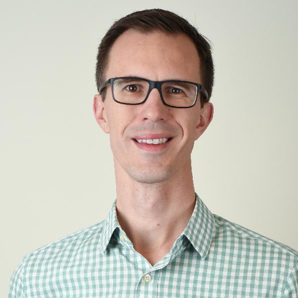 Dr. Stephen Marisette, seen from the chest up, wearing a green plaid shirt, glasses, and short brown hair