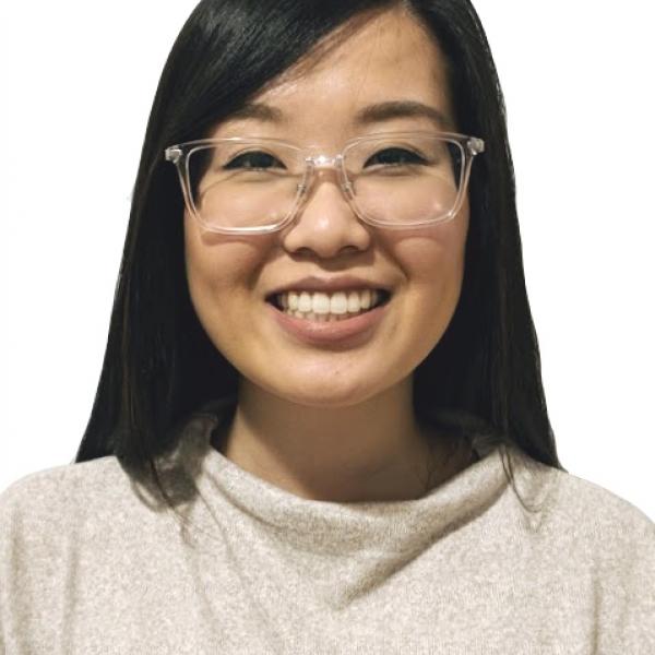Dr. Nicola Yang, seen from the shoulders up, wearing a tan sweater and glasses