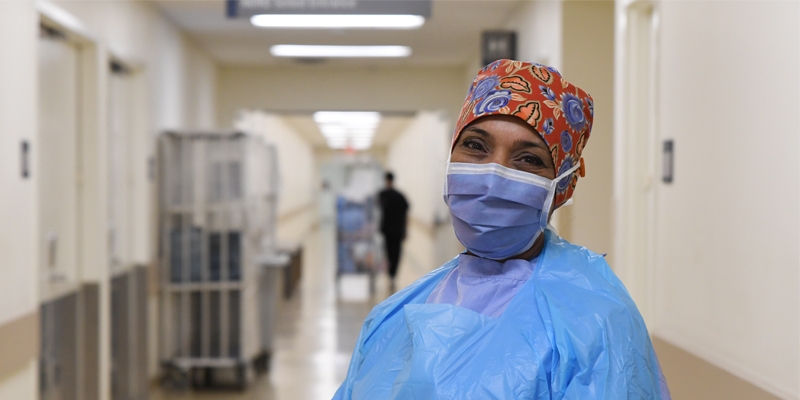 Amrit Chana, wearing scrubs, standing in a hospital hallway