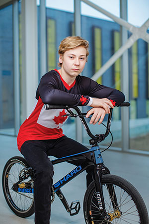 Colson Bates sits on his bmx bike and poses for a photo