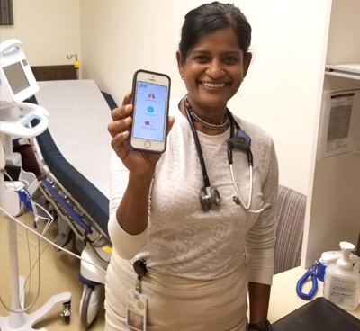 a nurse holds up her phone with mobile app Spectrum open