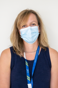 Amanda Inglis, seen from the chest up, wearing a black tank top, lanyard, long blonde hair, and medical mask
