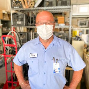 Terry King, seen from the waist up, wearing a blue collared shirt, glasses, and medical mask