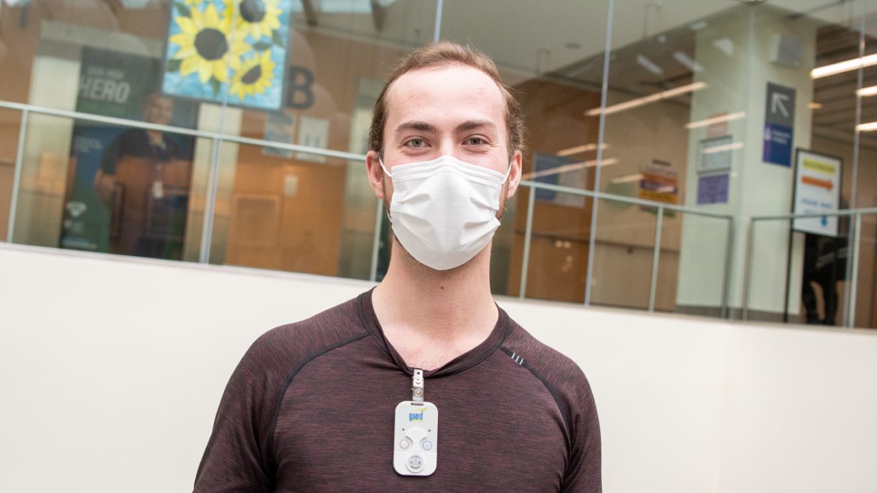 Benton Schmidt stands in a hospital lobby wearing a mask.