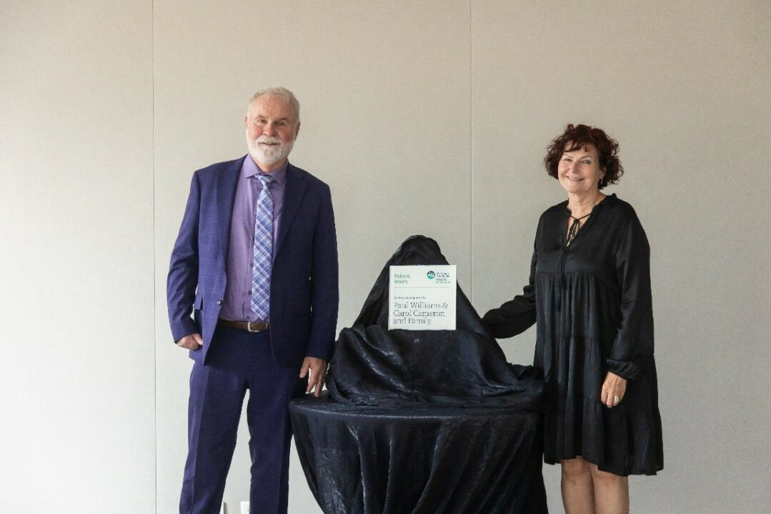 Carol and Paul stand next to a plaque recognizing their donation.