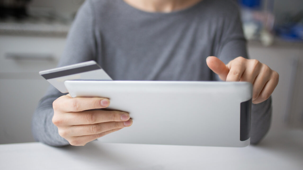 A women pays her bill using a credit card and a tablet